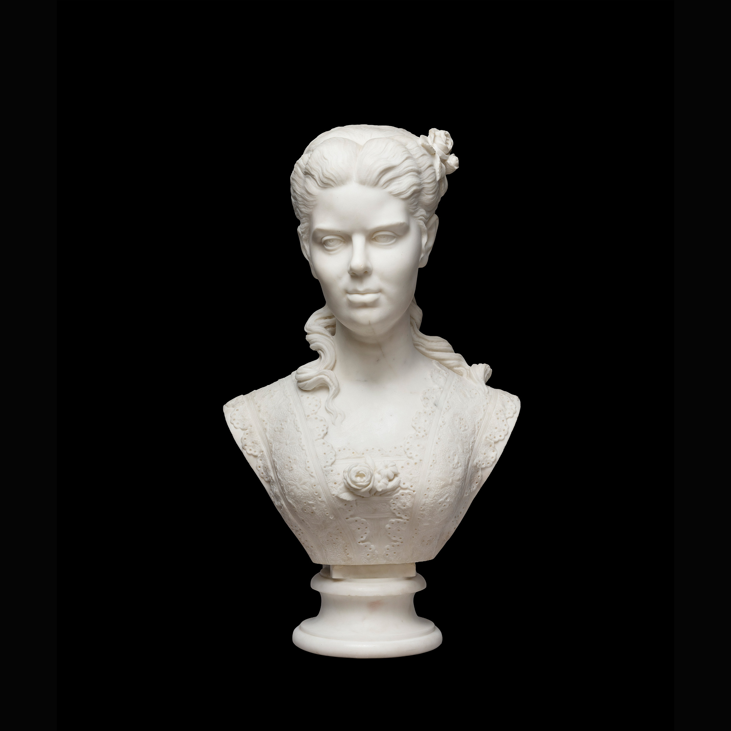 Front view of a marble statue depicting a woman from the shoulders up, with a 19th-century hairstyle.