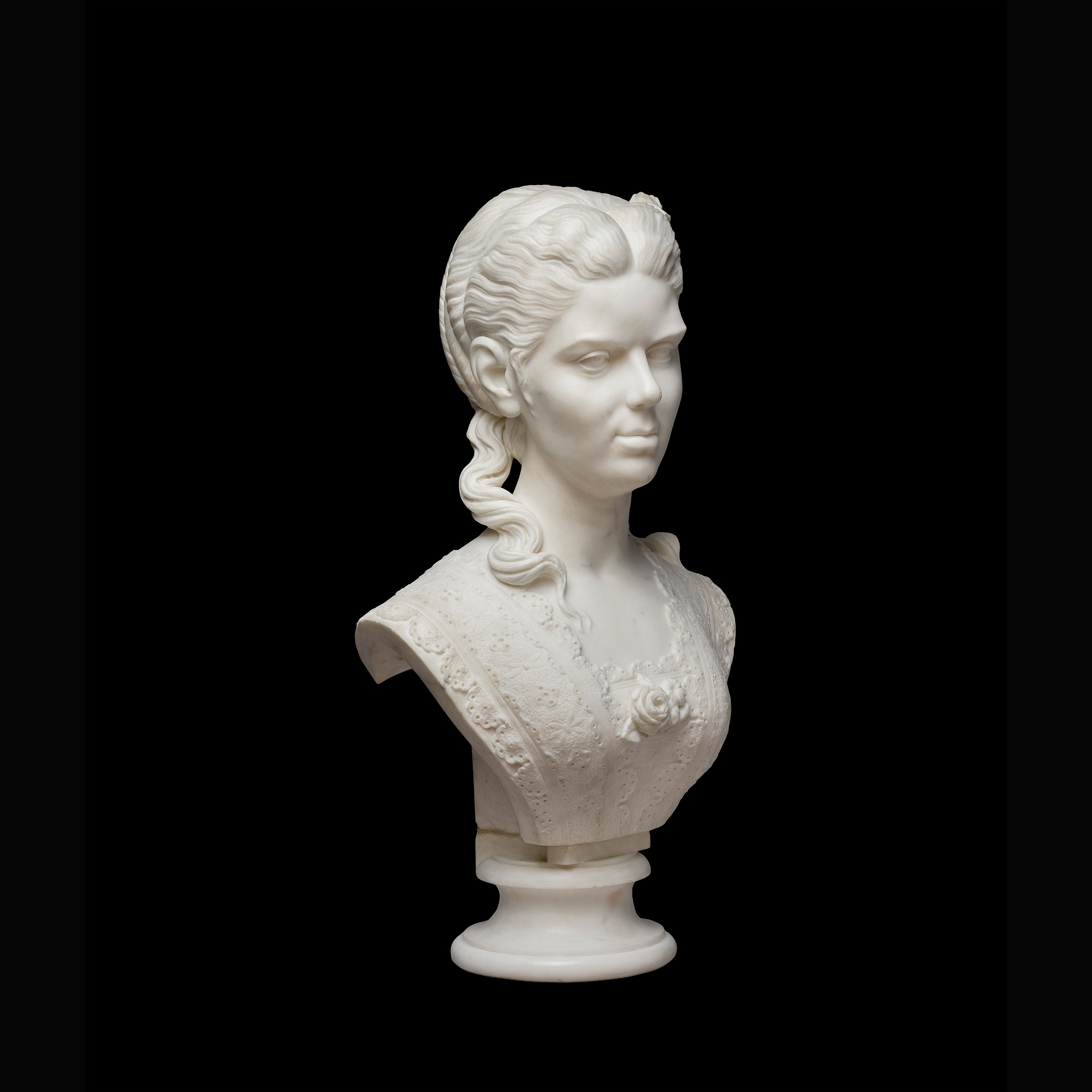 Three-quarter view of a marble statue depicting a woman from the shoulders up, with a 19th century hairstyle.