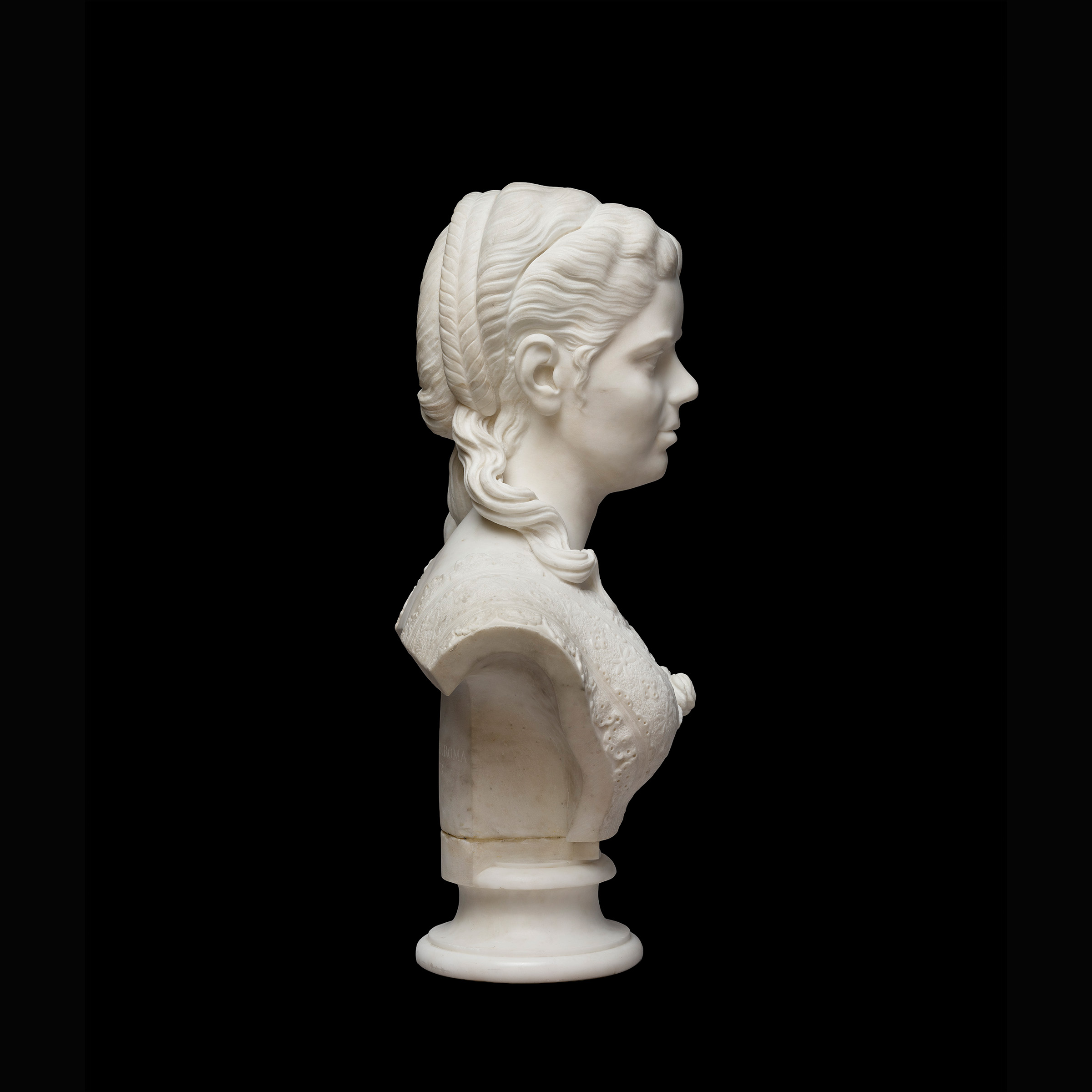 Side profile view of a marble statue depicting a woman from the shoulders up, with a 19th century hairstyle.