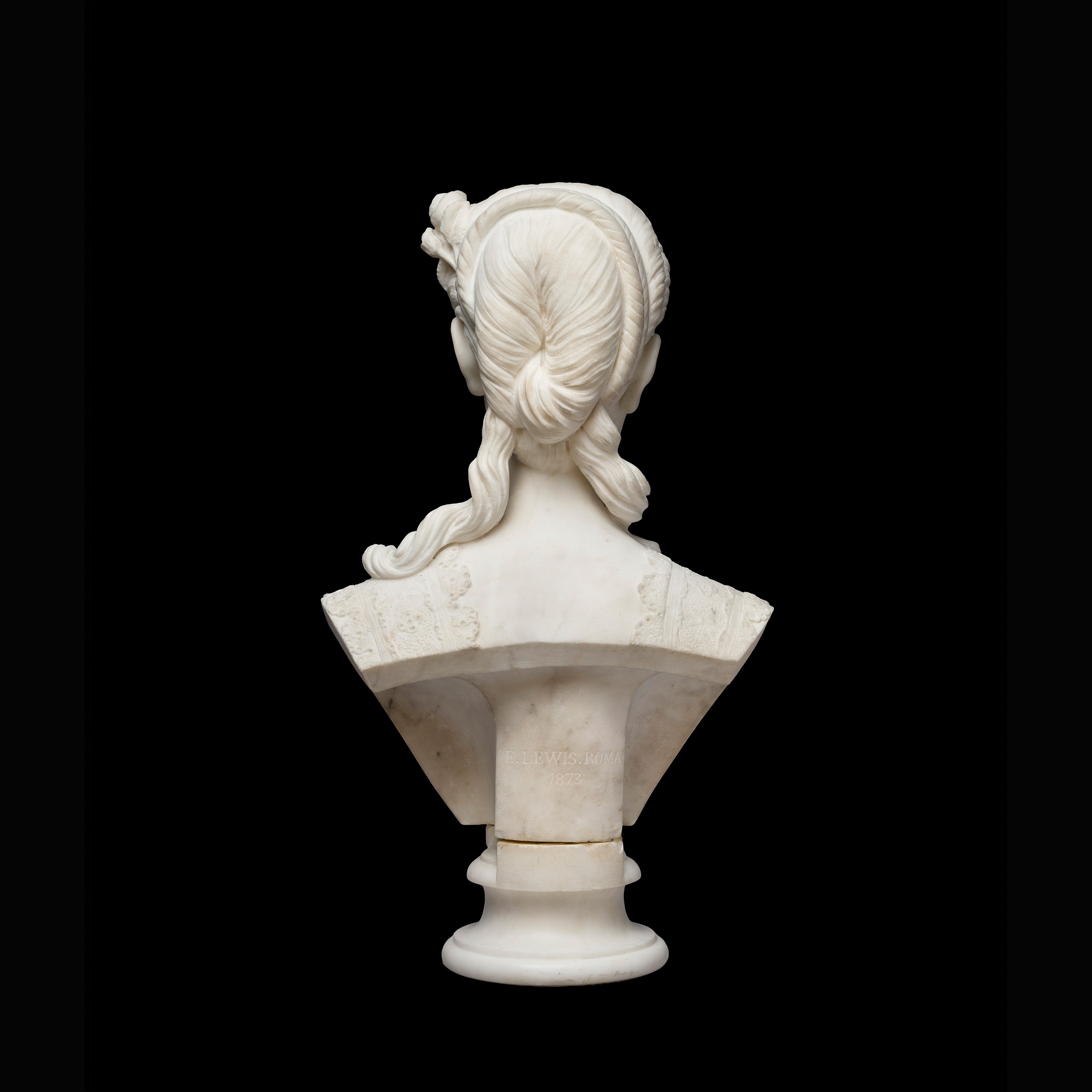 Back view of a marble statue depicting a woman from the shoulders up, with a 19th century hairstyle.