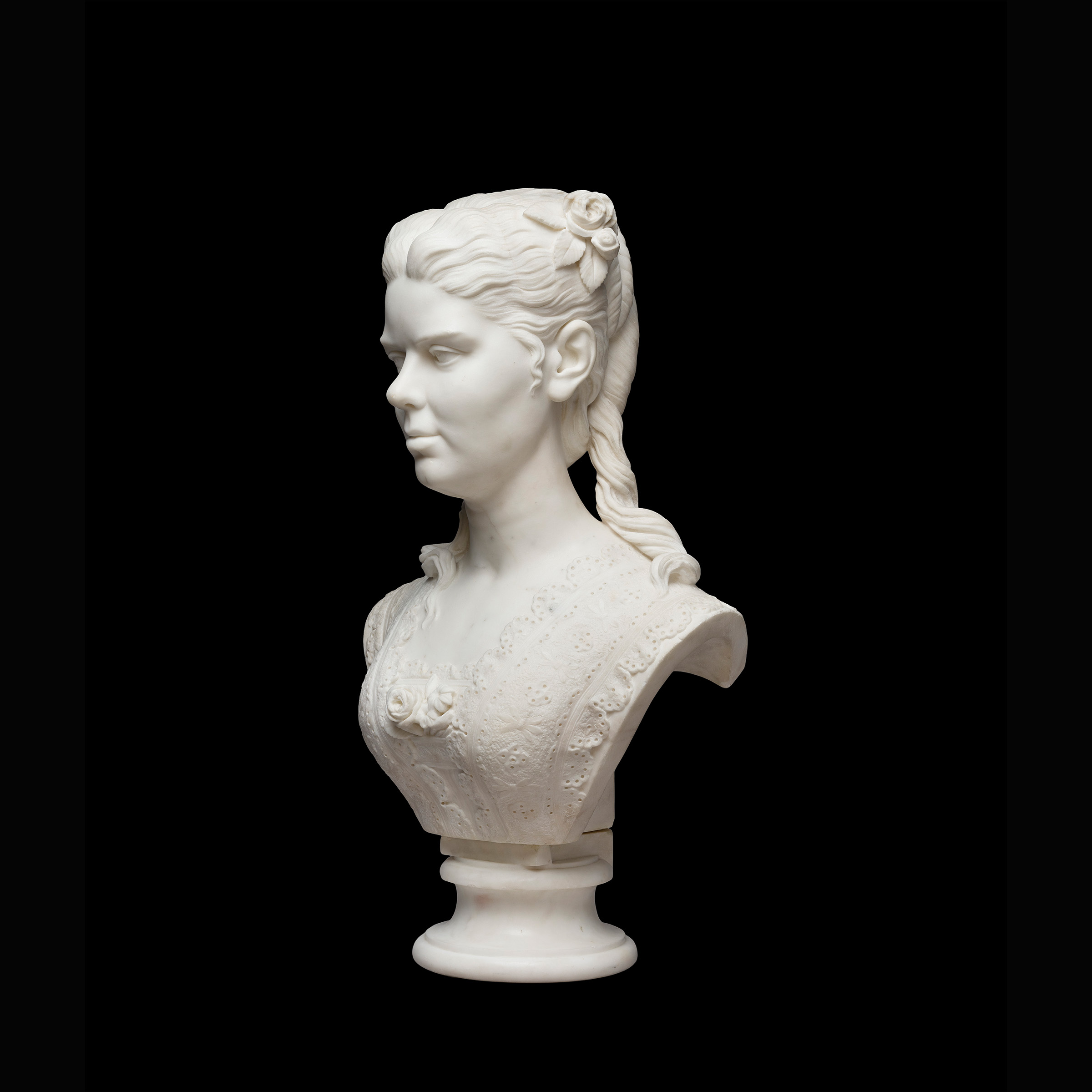 Three-quarter view of a marble statue depicting a woman from the shoulders up, with a 19th century hairstyle.