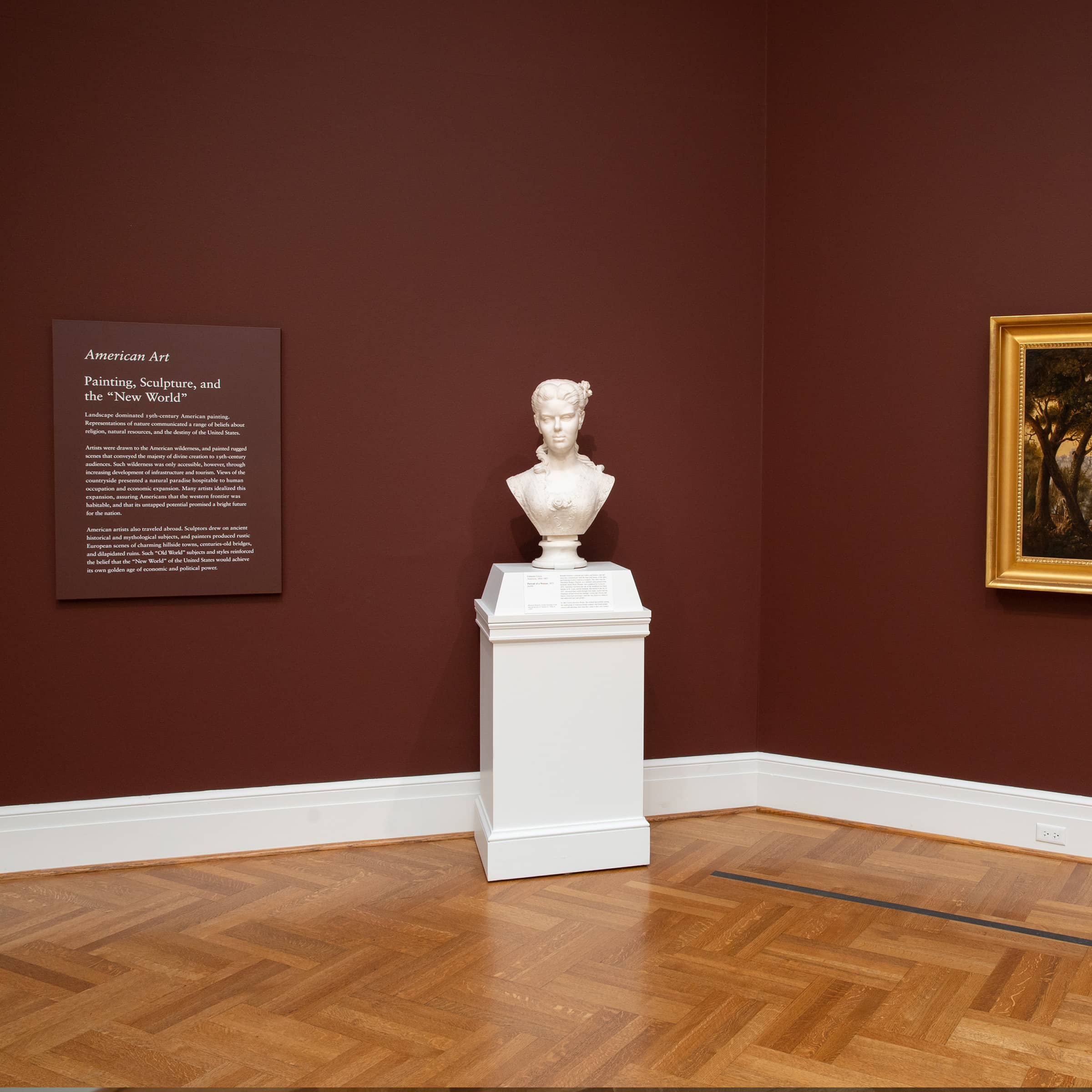 A marble sculpture of a woman, placed on a column in a museum gallery.
